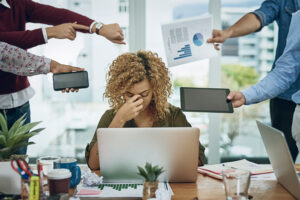 Shot of a young businesswoman looking stressed out in a demanding office environment.