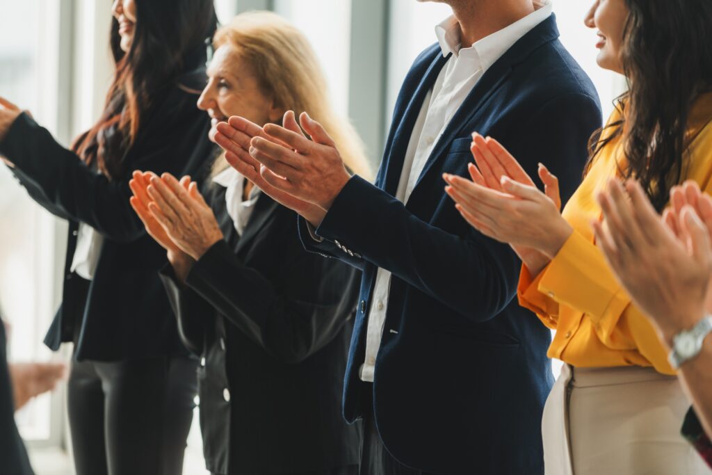 Group of business people clapping hands at successful presentation or conference.