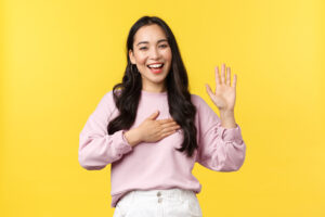 Woman with her hand on her heart, raising her other hand